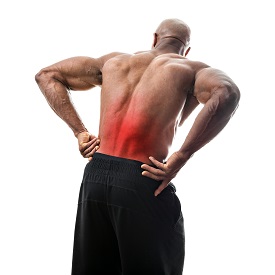 Fit man or athlete reaching for his lower back in pain with the painful area highlighted in red.